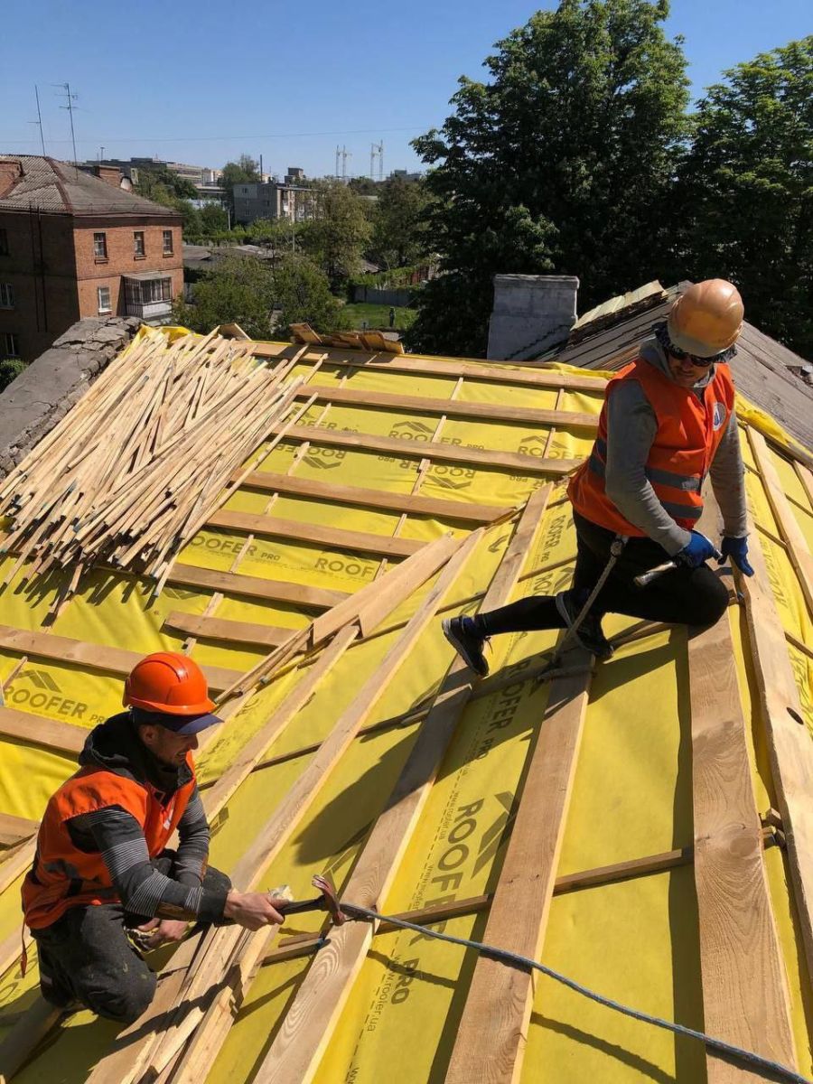 Фахівці КП «Харківжитлобуд» відновлюють покрівлю будинку в Слобідському районі. 